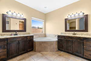 Bathroom with tiled tub and vanity