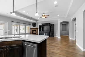 Kitchen featuring dishwasher, sink, pendant lighting, and dark hardwood / wood-style floors