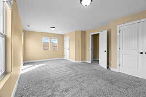 Unfurnished bedroom with carpet floors and a textured ceiling