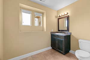 Bathroom with tile patterned flooring, vanity, and toilet