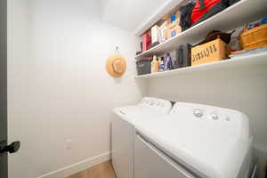 Laundry area with LVP floors and independent washer and dryer