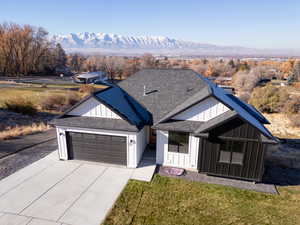 View of front of property featuring a mountain view, a garage, and a front yard