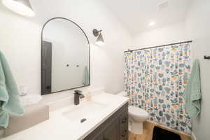 Bathroom with LVP floors, vanity, toilet, and a shower with curtain