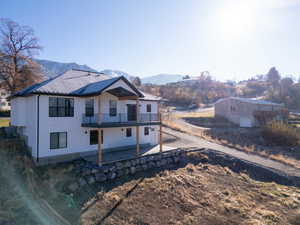 View of front of house with a mountain view, central air condition unit, and a patio