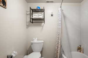 Bathroom with shower / tub combo and toilet