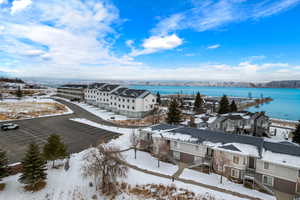 Snowy aerial view featuring a water view