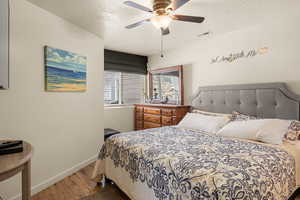 Bedroom featuring hardwood / wood-style floors, a textured ceiling, and ceiling fan