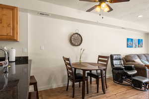 Dining room with ceiling fan, a textured ceiling, and hardwood / wood-style flooring