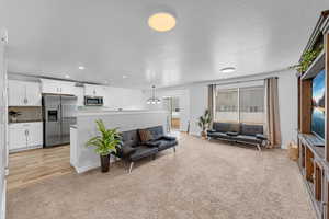 Carpeted living room with a textured ceiling