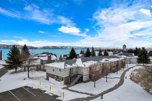 Snowy aerial view featuring a water and mountain view