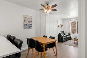 Dining area with ceiling fan, a textured ceiling, and light hardwood / wood-style flooring