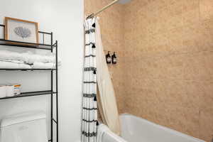 Bathroom featuring shower / bath combo with shower curtain and toilet