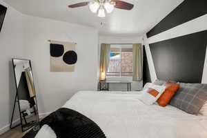 Bedroom featuring hardwood / wood-style floors, a textured ceiling, ceiling fan, and lofted ceiling