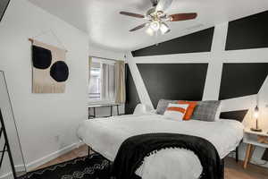 Bedroom featuring a textured ceiling, light hardwood / wood-style flooring, ceiling fan, and lofted ceiling