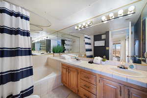 Bathroom with tile patterned flooring, vanity, and shower / bath combo with shower curtain