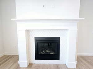 Room details with wood-type flooring and a tile fireplace