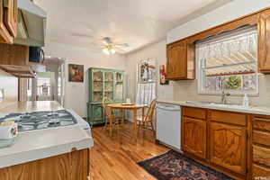 Kitchen with a textured ceiling, white appliances, sink, and a wealth of natural light