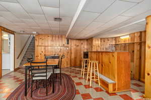 Dining space with bar, wood walls, and washer / dryer