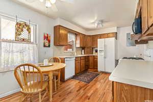 Kitchen with ceiling fan, sink, light hardwood / wood-style floors, a textured ceiling, and white appliances