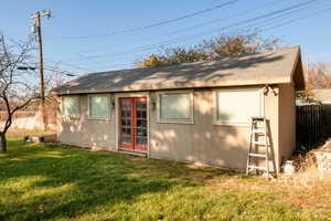 Back of property featuring an outbuilding and a yard