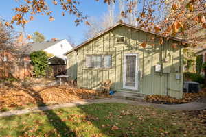 Back of house with a carport and cooling unit