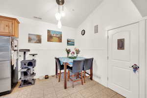 Tiled dining area with lofted ceiling