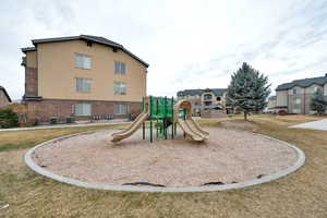 View of jungle gym with cooling unit and a lawn