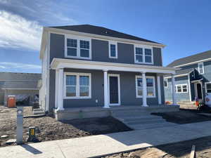 American foursquare style home featuring a porch and central air condition unit