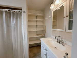 Bathroom featuring a textured ceiling, vanity, tile patterned floors, and curtained shower