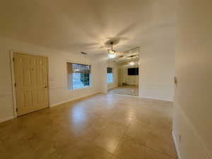 Unfurnished room with light tile patterned floors and ceiling fan