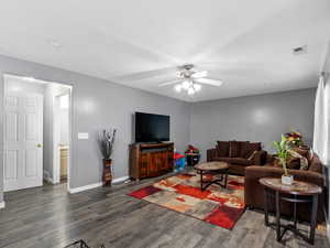 Living room featuring ceiling fan and dark hardwood / wood-style floors