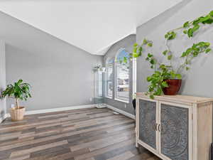 Entrance foyer featuring dark hardwood / wood-style flooring and vaulted ceiling