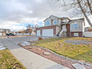 Front of property featuring a garage and a front lawn