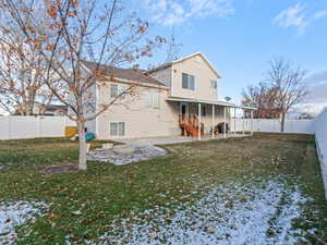 Rear view of house with a yard and a patio