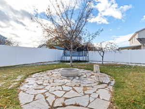 View of patio featuring a fire pit and a trampoline