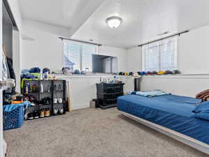 Carpeted bedroom featuring a textured ceiling