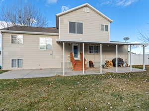 Back of property with a yard and a patio area