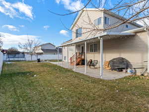 Rear view of house featuring a lawn and a patio