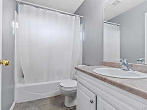 Full bathroom featuring shower / bath combo, vanity, and toilet