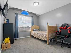 Carpeted bedroom with vaulted ceiling