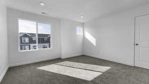 Spare room featuring carpet flooring and a healthy amount of sunlight