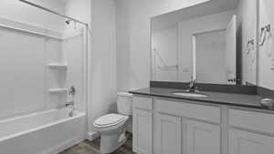 Full bathroom featuring bathing tub / shower combination, hardwood / wood-style floors, vanity, and toilet