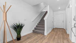 Staircase featuring hardwood / wood-style floors and a textured ceiling