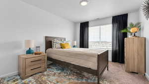 Bedroom with carpet floors and a textured ceiling