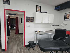 Office with a textured ceiling and dark wood-type flooring