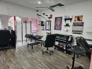 Office with a textured ceiling, hardwood / wood-style flooring, and ceiling fan