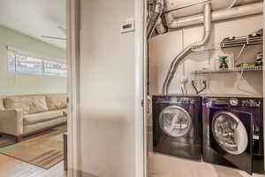 Washroom featuring separate washer and dryer and hardwood / wood-style flooring