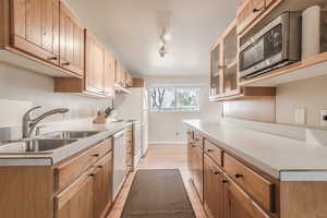 Kitchen featuring white appliances, light hardwood / wood-style flooring, and sink