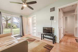 Living room with ceiling fan, light hardwood / wood-style floors, and built in shelves