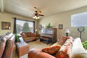 Living room with ceiling fan and light colored carpet